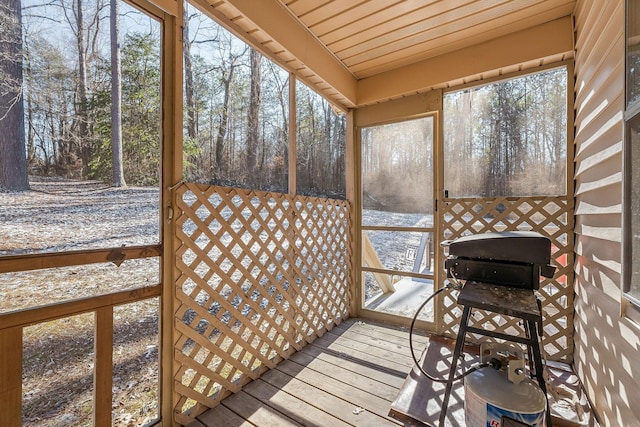 sunroom / solarium with a healthy amount of sunlight and wooden ceiling