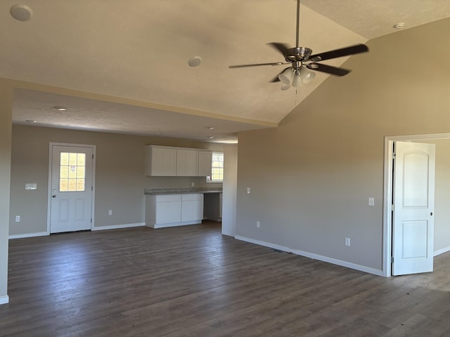 unfurnished living room with dark wood-type flooring, high vaulted ceiling, and ceiling fan