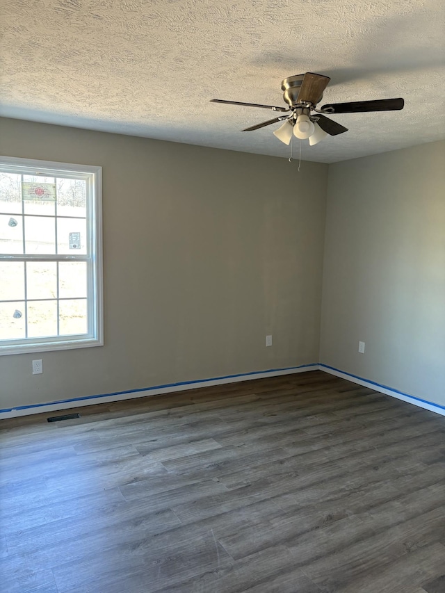 unfurnished room featuring ceiling fan, dark wood-type flooring, and a textured ceiling