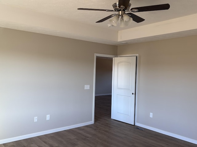 empty room featuring ceiling fan and dark hardwood / wood-style floors