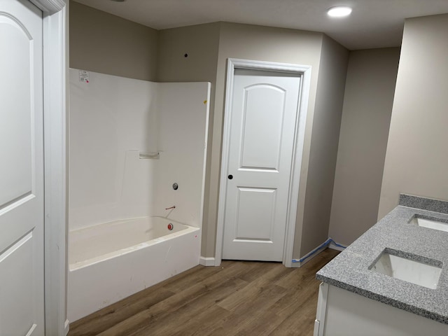 bathroom with shower / washtub combination, hardwood / wood-style flooring, and vanity