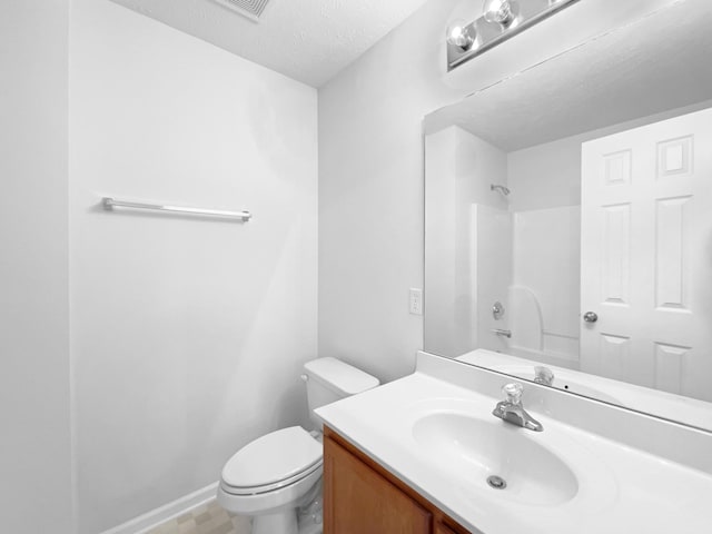 full bathroom with a textured ceiling, toilet, vanity, and shower / washtub combination