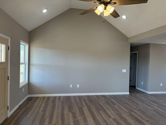 empty room with vaulted ceiling, ceiling fan, and dark hardwood / wood-style floors