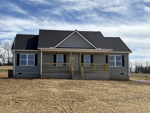 view of front of property with crawl space, covered porch, and roof with shingles