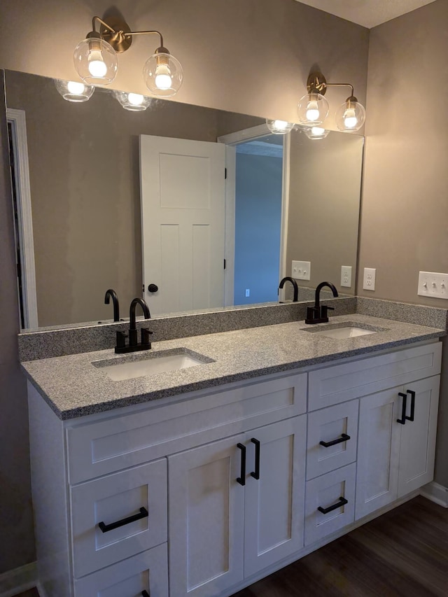 bathroom featuring double vanity, a sink, and wood finished floors