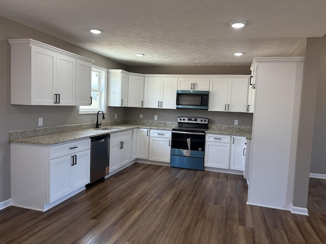 kitchen with stainless steel appliances, a sink, dark wood finished floors, and white cabinets