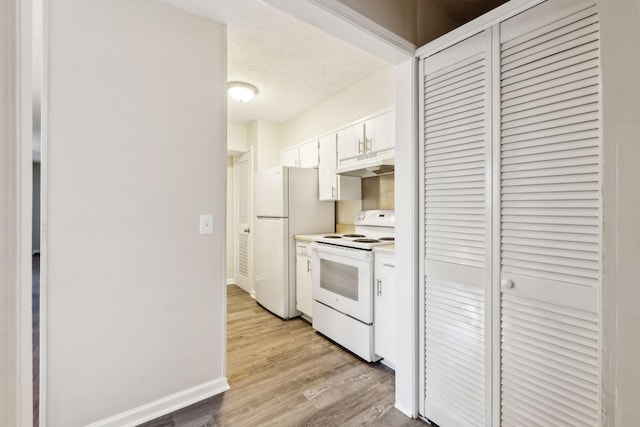 kitchen featuring light hardwood / wood-style floors, white appliances, white cabinets, and a textured ceiling