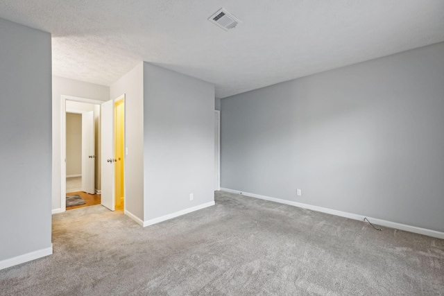 carpeted spare room with a textured ceiling