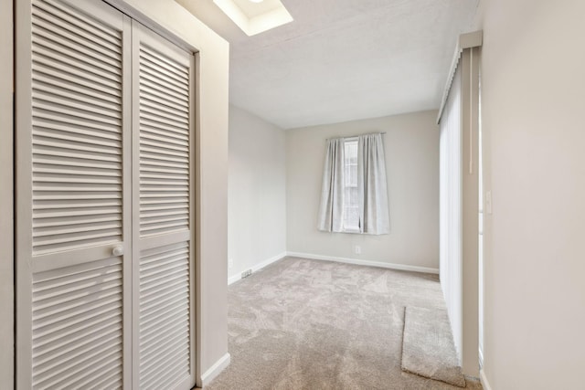 unfurnished bedroom with a skylight and light colored carpet