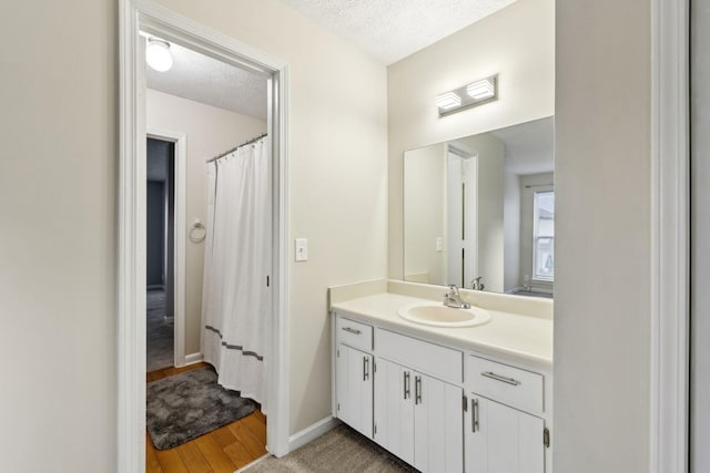 bathroom featuring wood-type flooring, a textured ceiling, and vanity