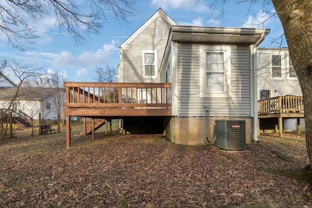 back of house with central air condition unit and a wooden deck