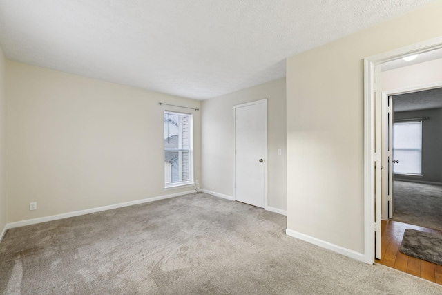 carpeted empty room featuring a textured ceiling