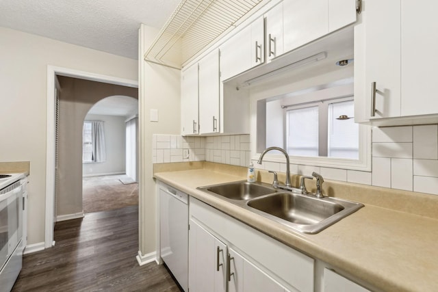 kitchen featuring white appliances, a textured ceiling, white cabinetry, decorative backsplash, and sink