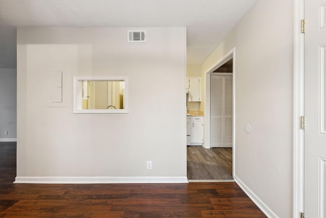 unfurnished room with dark hardwood / wood-style floors and a textured ceiling