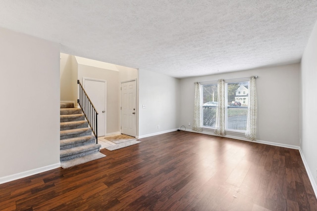 empty room with a textured ceiling and dark wood-type flooring