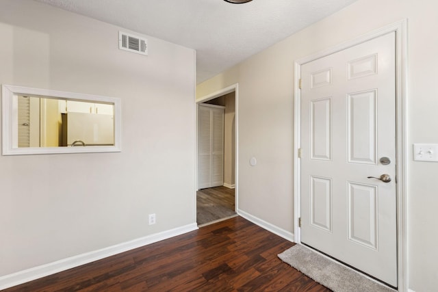 interior space featuring a textured ceiling and dark hardwood / wood-style flooring