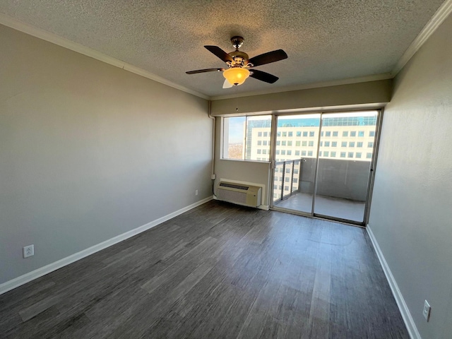 empty room featuring dark wood-type flooring, a textured ceiling, ornamental molding, and a wall mounted air conditioner