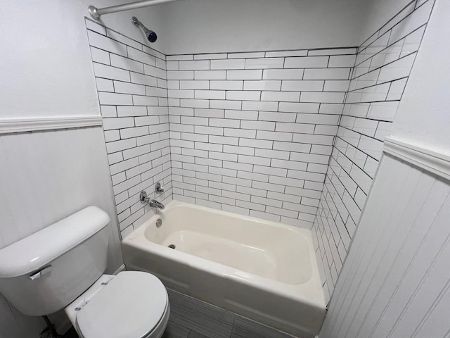 bathroom featuring toilet, tile patterned floors, and tiled shower / bath