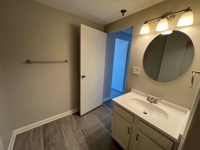 bathroom featuring a textured ceiling, hardwood / wood-style floors, and vanity