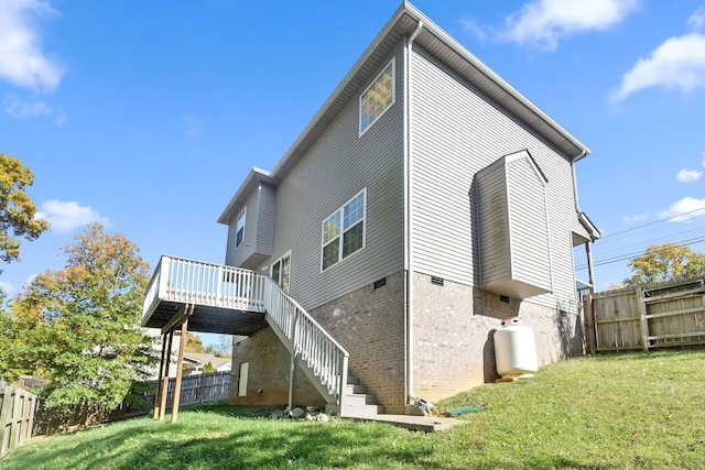 back of house featuring a lawn and a deck