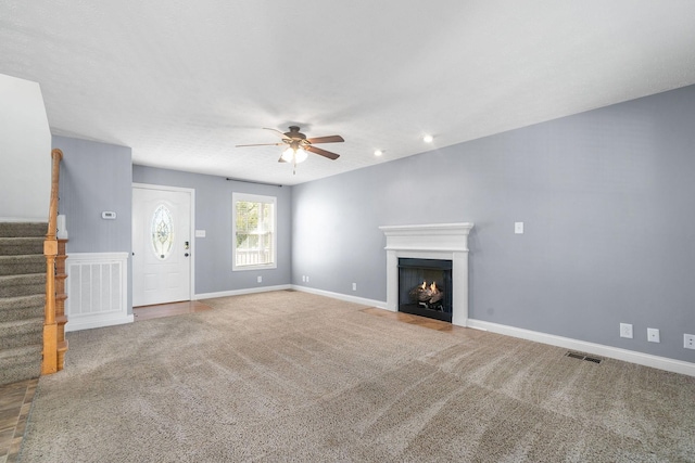 unfurnished living room with carpet and ceiling fan