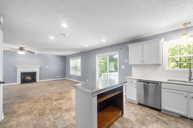 kitchen with sink, white cabinetry, dishwasher, and light colored carpet