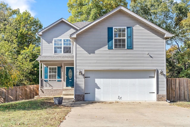 view of property with covered porch and a garage