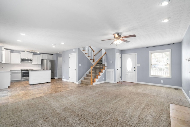 unfurnished living room with light carpet and ceiling fan