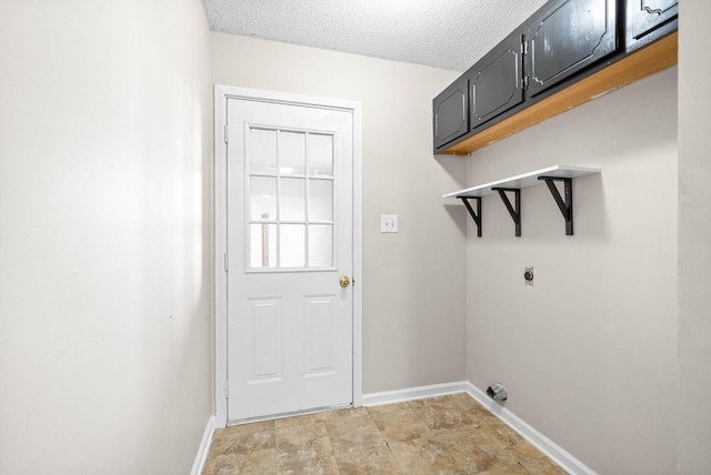 laundry room featuring cabinets, a textured ceiling, and hookup for an electric dryer