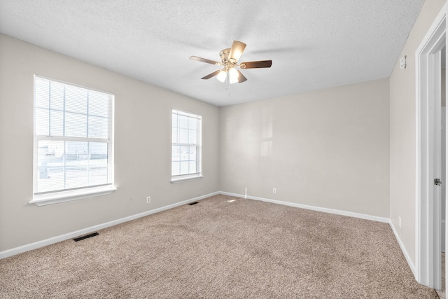 carpeted spare room with ceiling fan and a textured ceiling