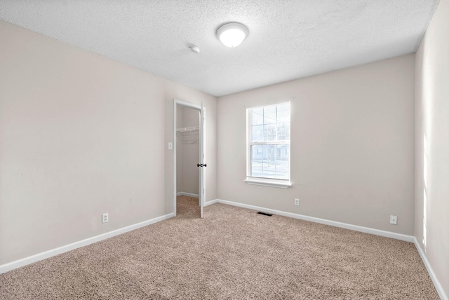 unfurnished room featuring carpet floors and a textured ceiling