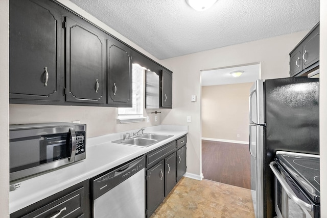 kitchen featuring a textured ceiling, appliances with stainless steel finishes, and sink