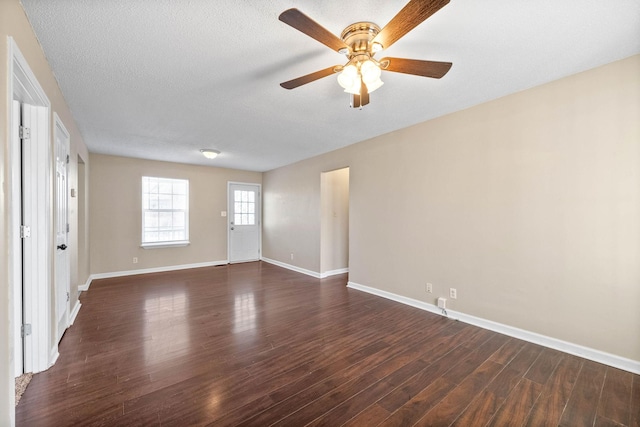 spare room featuring a textured ceiling, dark wood-type flooring, and ceiling fan