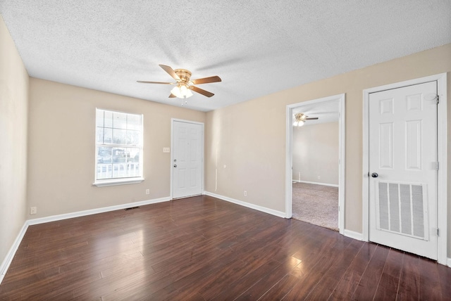 spare room with ceiling fan, a textured ceiling, and dark hardwood / wood-style floors