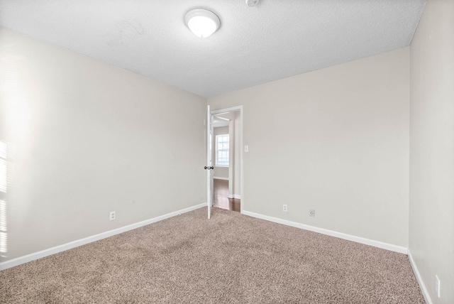 spare room with a textured ceiling and carpet floors