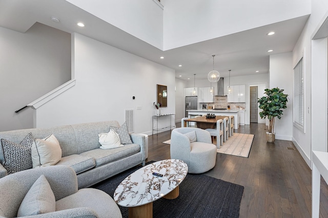 living room with a high ceiling and dark hardwood / wood-style floors