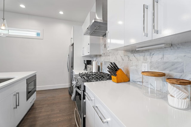 kitchen with white cabinetry, stainless steel appliances, backsplash, hanging light fixtures, and range hood