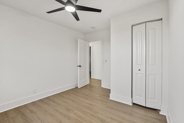 unfurnished bedroom featuring ceiling fan, a closet, and light hardwood / wood-style flooring