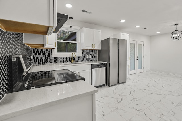 kitchen with backsplash, sink, white cabinetry, hanging light fixtures, and appliances with stainless steel finishes