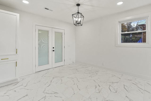 unfurnished dining area with french doors and an inviting chandelier