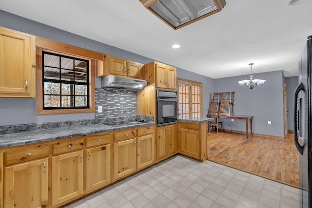 kitchen with pendant lighting, black appliances, decorative backsplash, kitchen peninsula, and an inviting chandelier