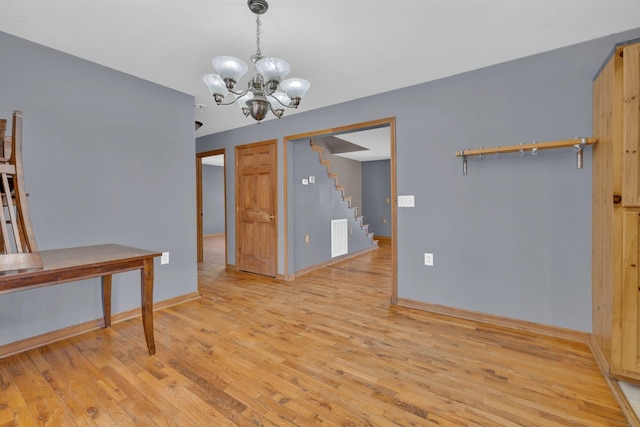 unfurnished dining area with an inviting chandelier and light hardwood / wood-style flooring