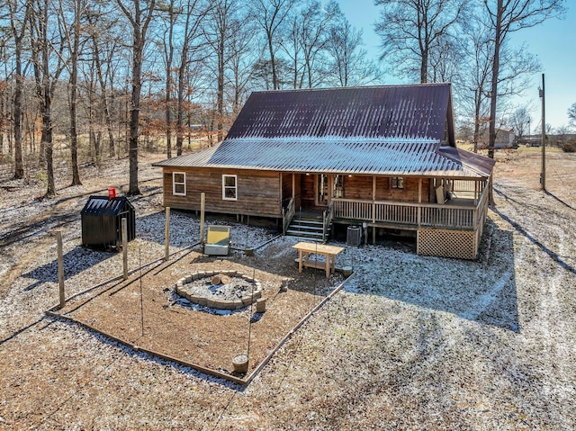 exterior space with central AC unit and a fire pit