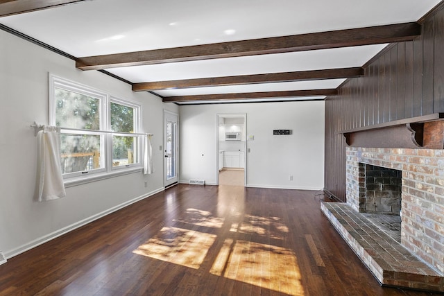 unfurnished living room with a brick fireplace, dark hardwood / wood-style flooring, and beamed ceiling