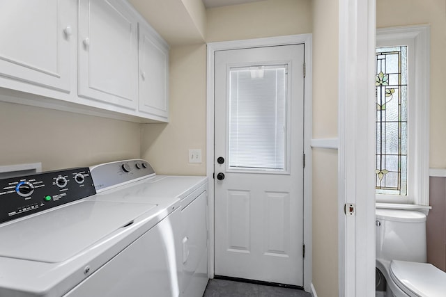 clothes washing area featuring cabinets and washing machine and dryer