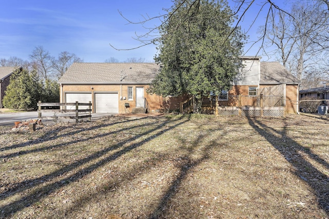 back of house with a lawn, a deck, and a garage