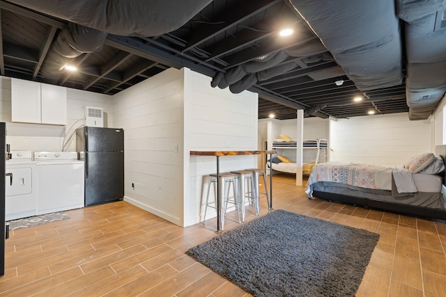 basement featuring separate washer and dryer and black refrigerator