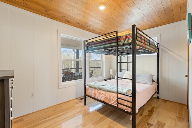 bedroom featuring wooden ceiling, hardwood / wood-style floors, and wooden walls