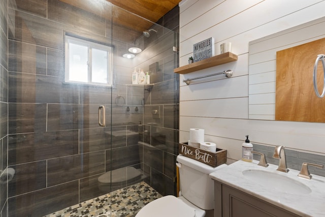 bathroom featuring vanity, toilet, an enclosed shower, and wooden walls