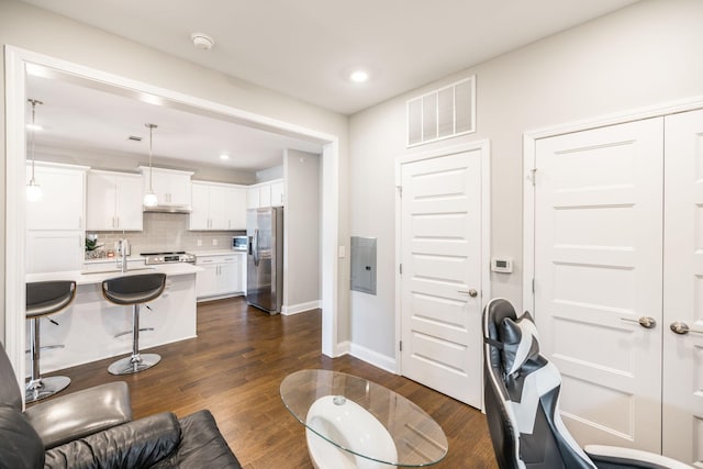 living room with sink, electric panel, and dark hardwood / wood-style flooring